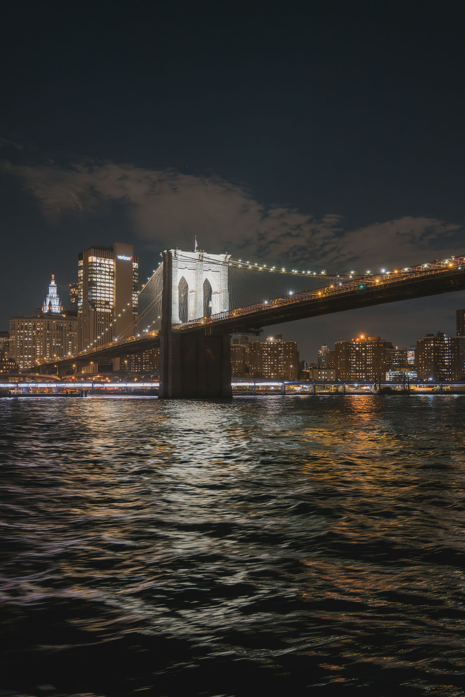 Vista verticale del ponte di Brooklyn illuminato con lo skyline di Manhattan