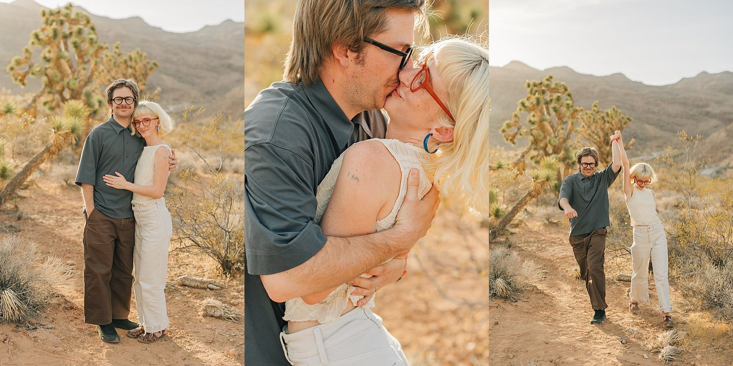 Couple kissing and embracing in Joshua Tree desert landscape with mountains, blonde woman in white, man in blue shirt.