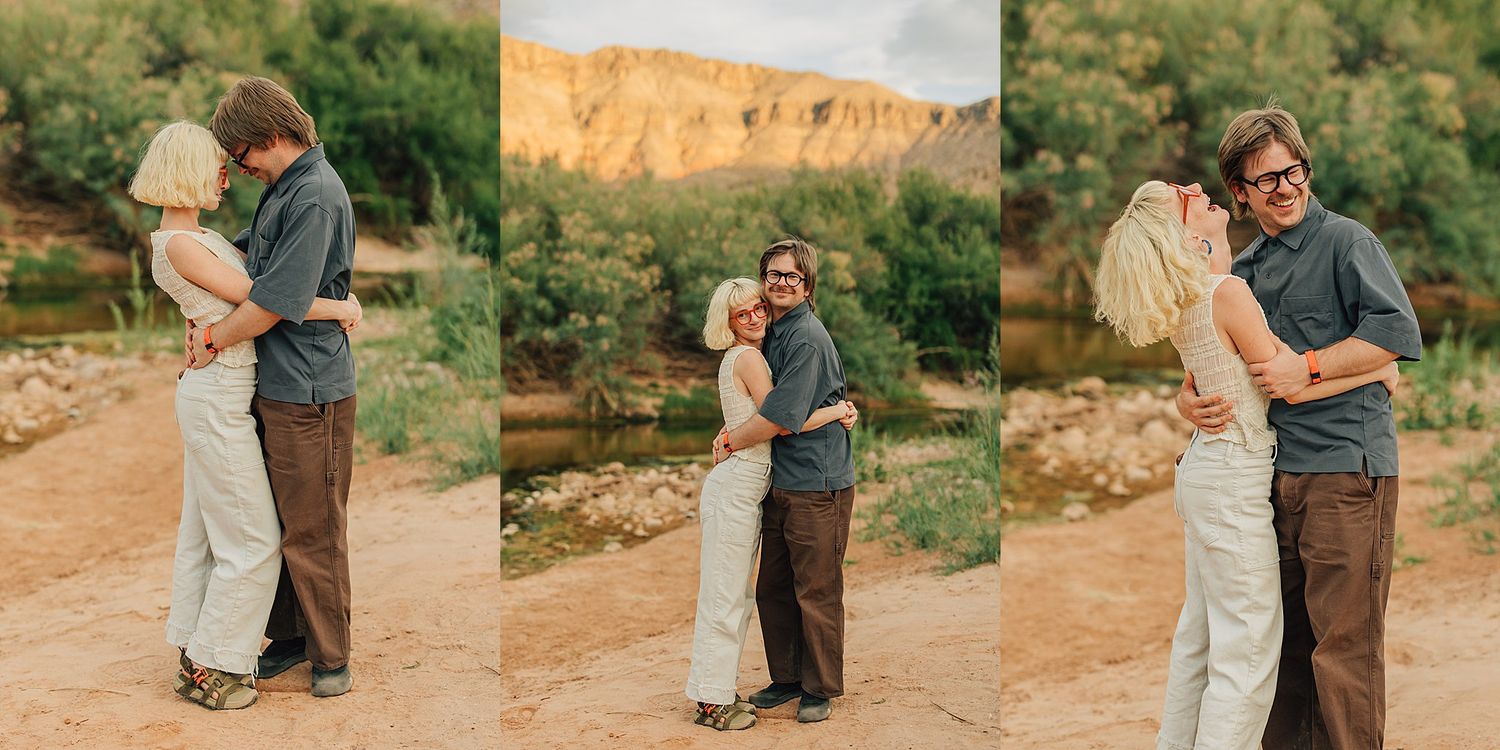 Couple embracing and kissing outdoors near a desert canyon river with sandy terrain and golden cliffs at sunset.