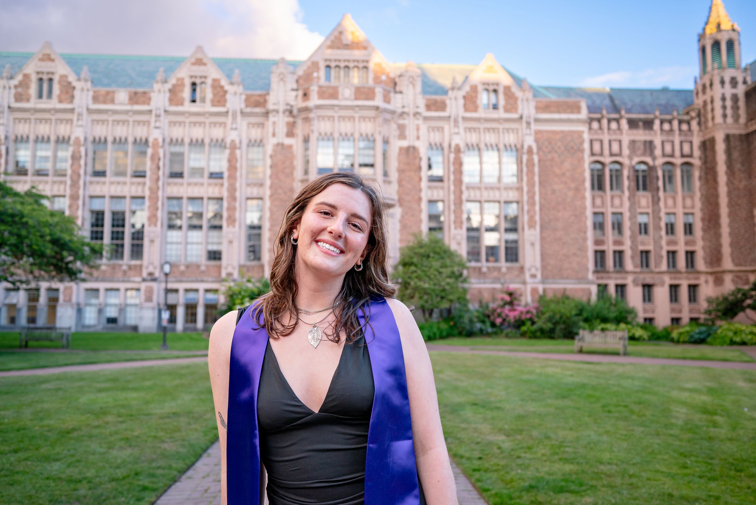 University of Washington graduate posing in front of historic Raitt Hall