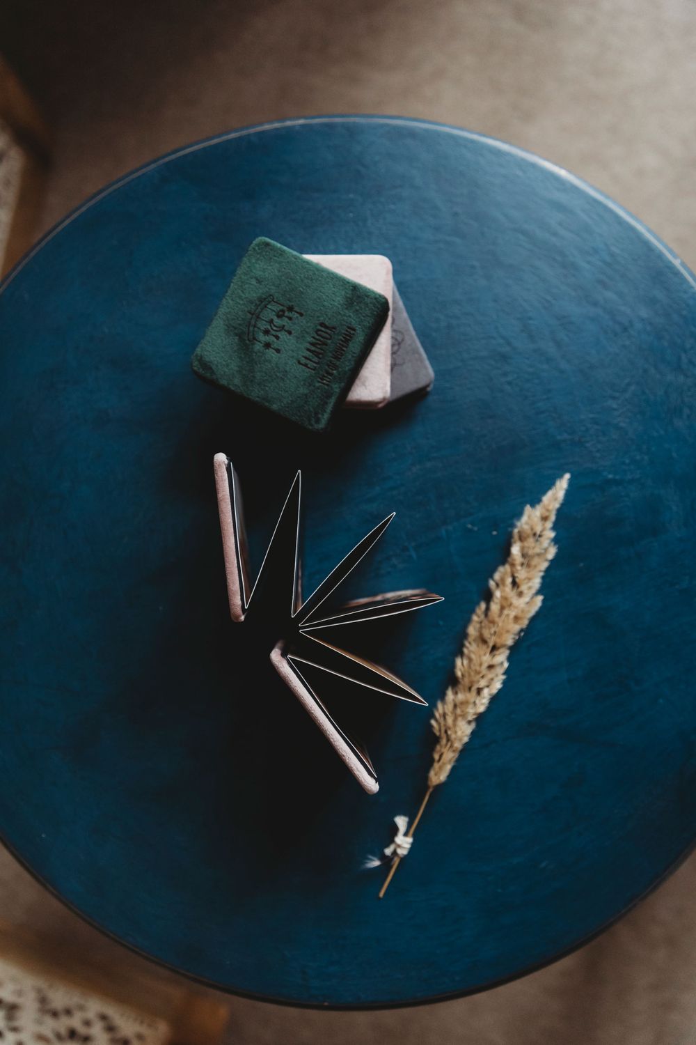 Metal clips and dried wheat arranged on a blue circular surface.