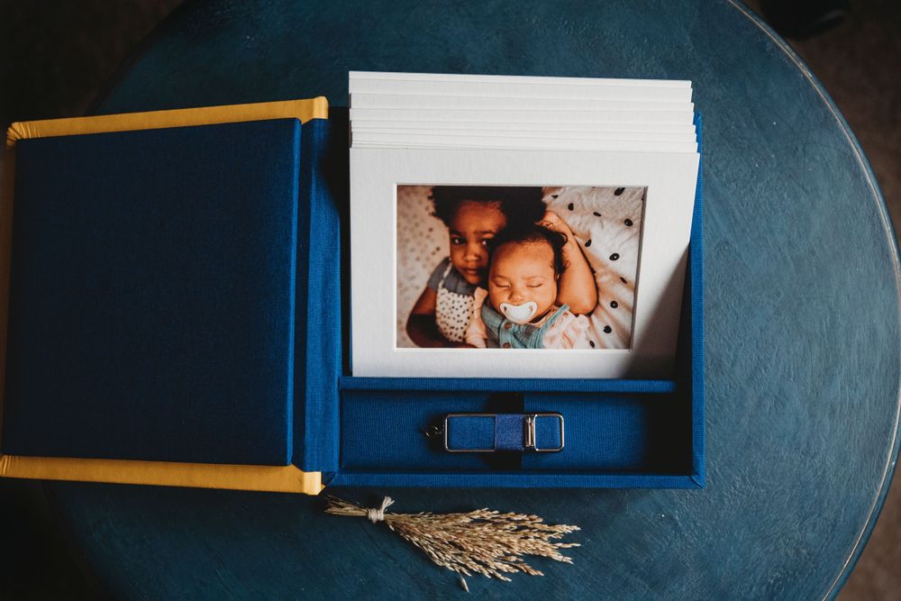 A blue photo album box opened to display a photograph on a dark surface.