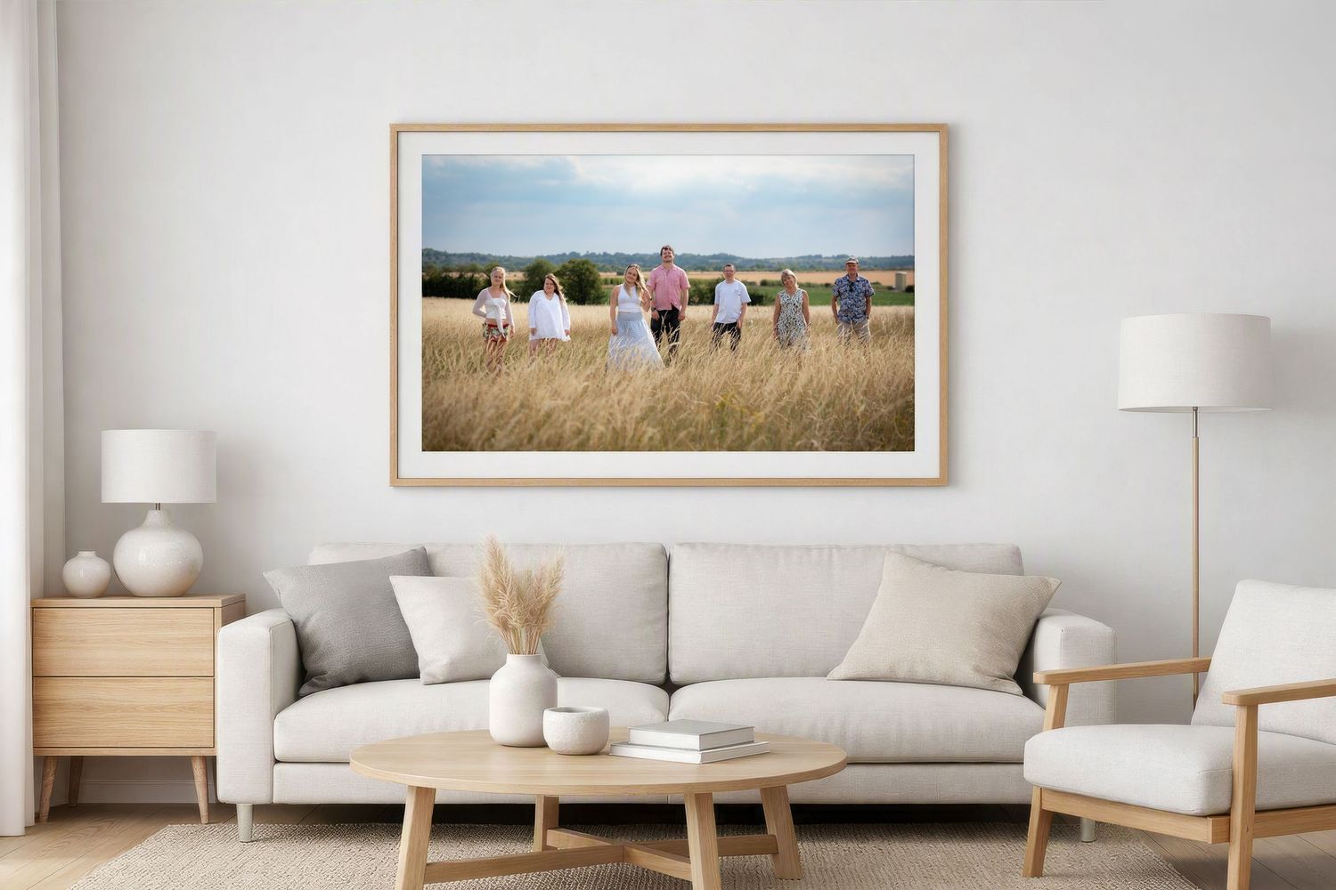 Framed panoramic photo of people in a field displayed above a white sofa in a bright modern living room.