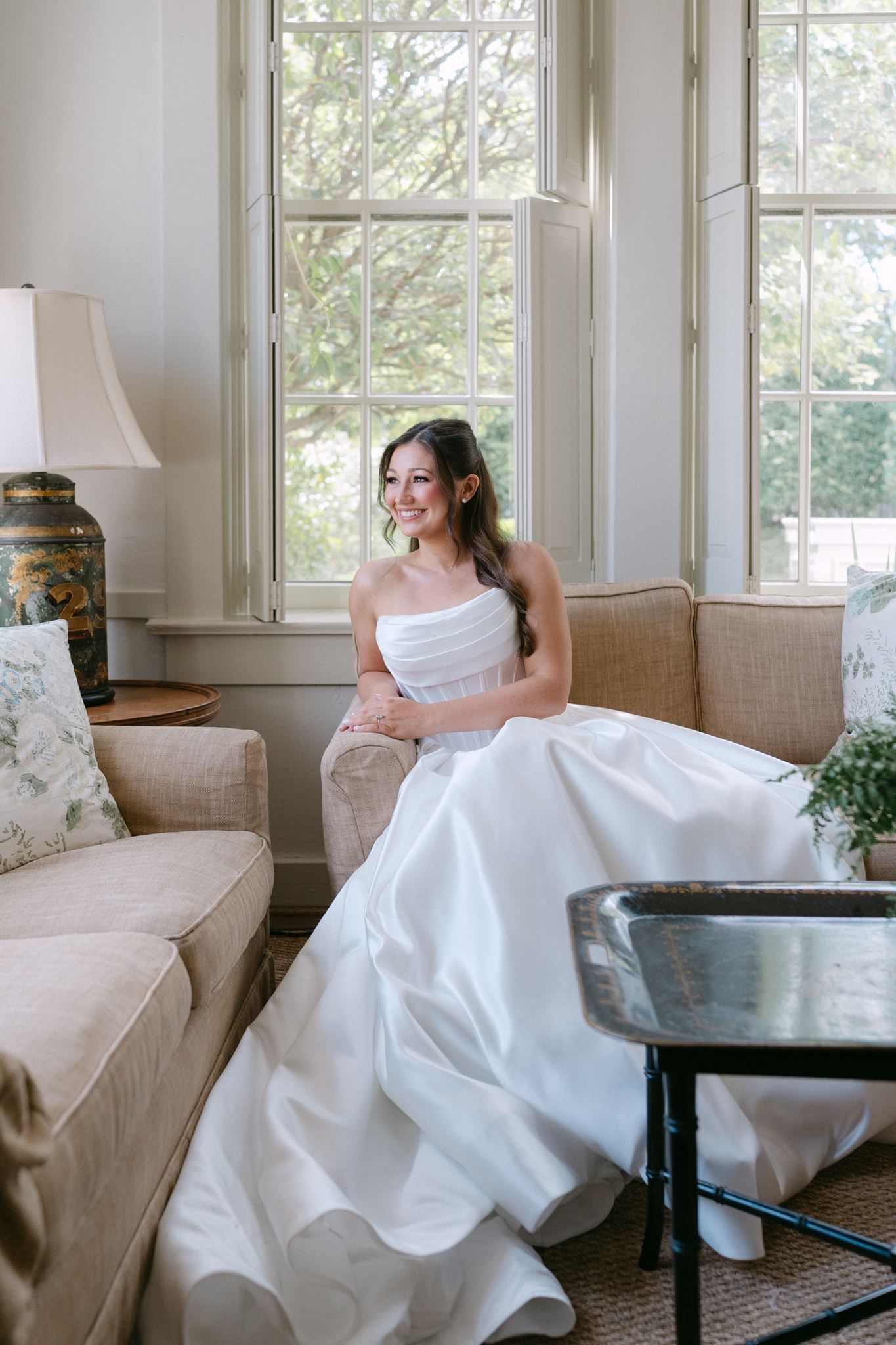 Emma in her wedding dress, sitting on a sofa at the River Oaks Garden Club in Houston.