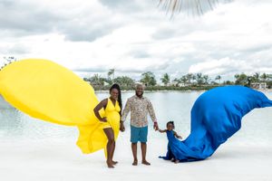 Yellow and blue flowing fabrics create a dramatic scene by a tranquil lake.