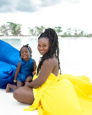 Yellow and blue flowing fabric creates dramatic beachside portrait.
