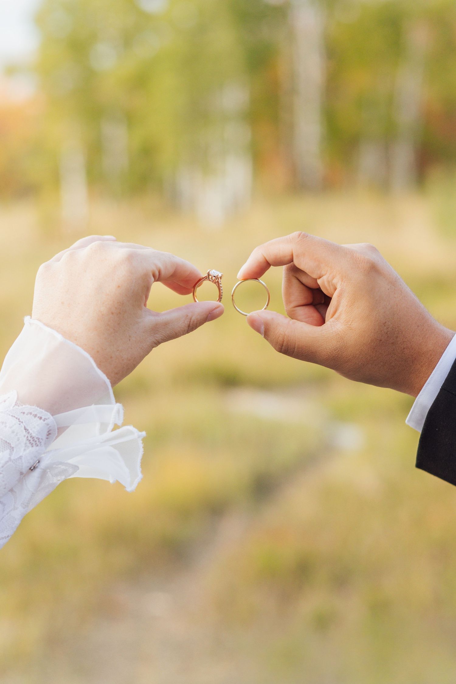 Bride and groom sitting on green grass, sharing a romantic moment, bride holding blue and white floral bouquet.
