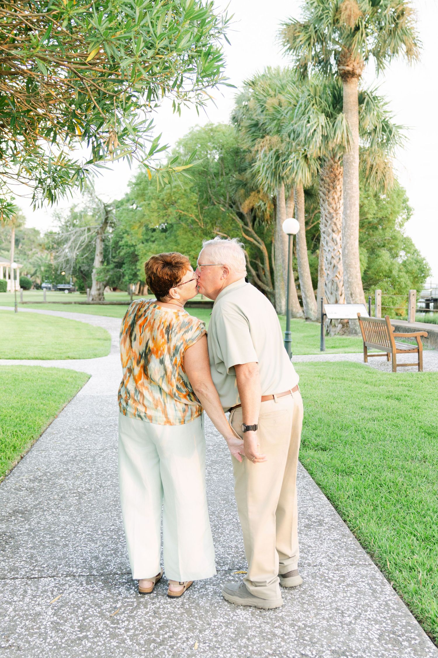 Lori and Kenny kiss on a garden path in Jekyll Island’s Historic District during their 45th anniversary portrait session