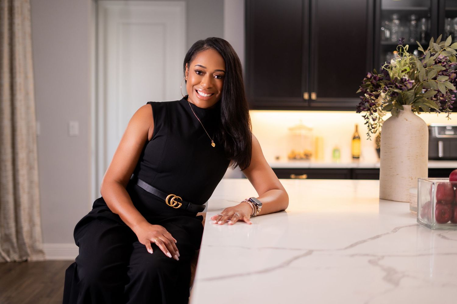 Orlando personal branding photographer Ray Alvarez — interior designer Brandy in black outfit leaning on marble kitchen counter at client ho