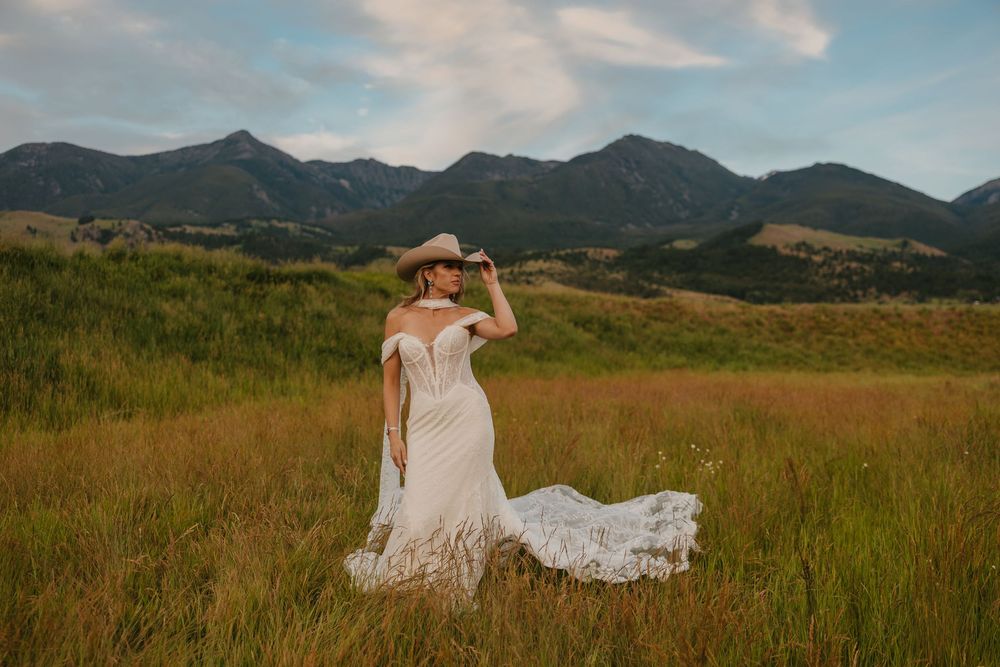 Bride shows of her wedding dress and Stetson Cowboy hat in Paradise Valley, Montana at Copper Rose Ranch captured by Wedding Photographer