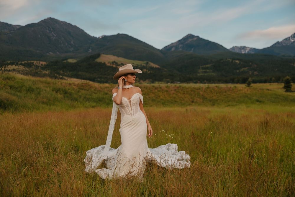 Bride shows of her wedding dress and Stetson Cowboy hat in Paradise Valley, Montana at Copper Rose Ranch captured by Wedding Photographer
