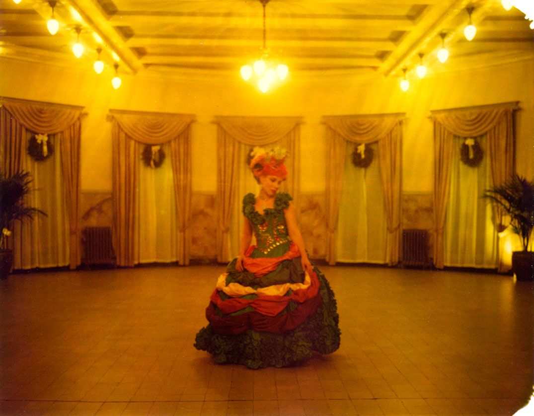Panoramic view of an elegant ballroom with ornate gold decor, crystal chandeliers and warm lighting creating a luxurious ambiance.