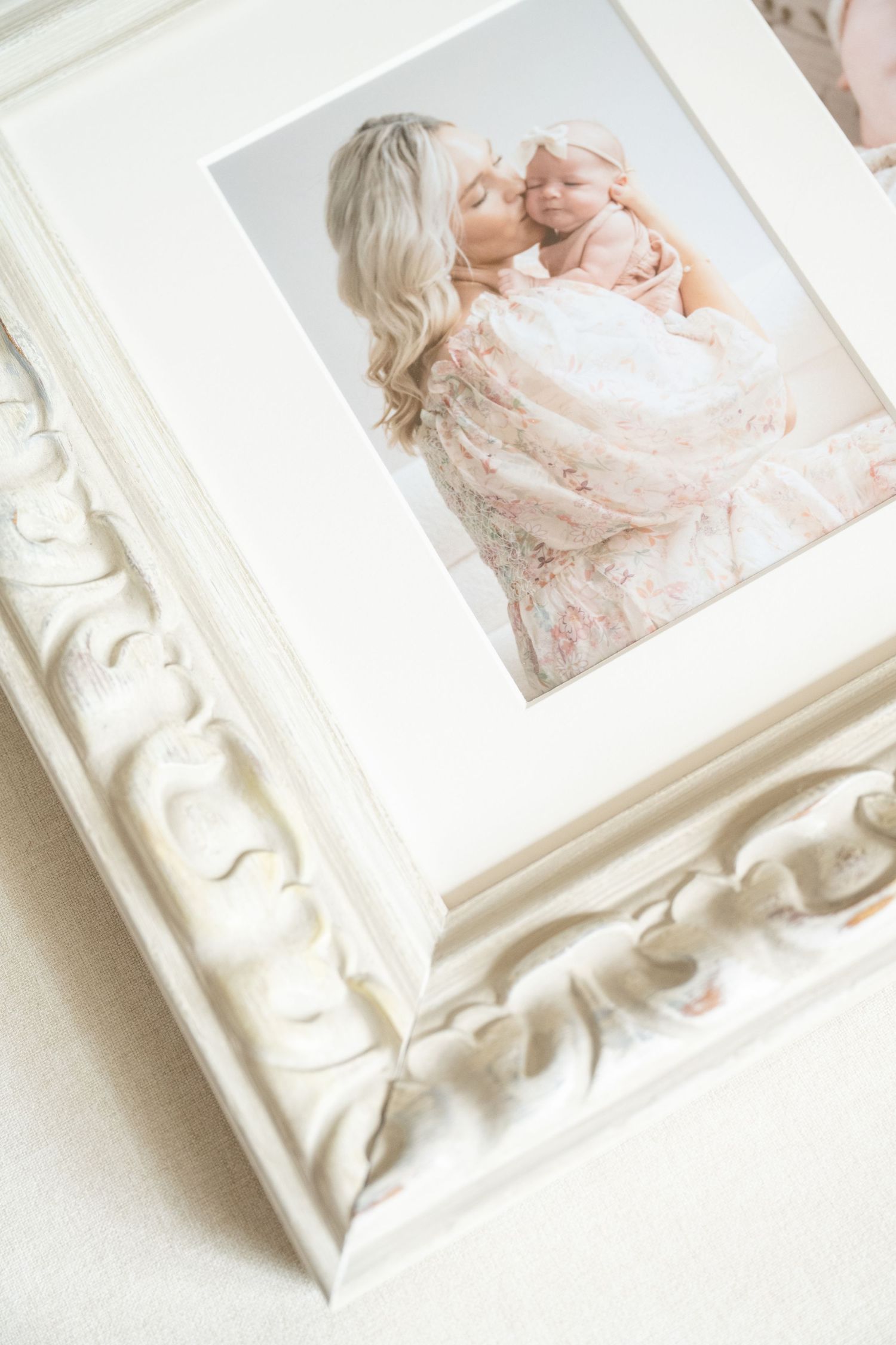 Custom framed print of Mom kissing newborn baby girl during in studio session in stillwater MN with Jagger Rose Photography