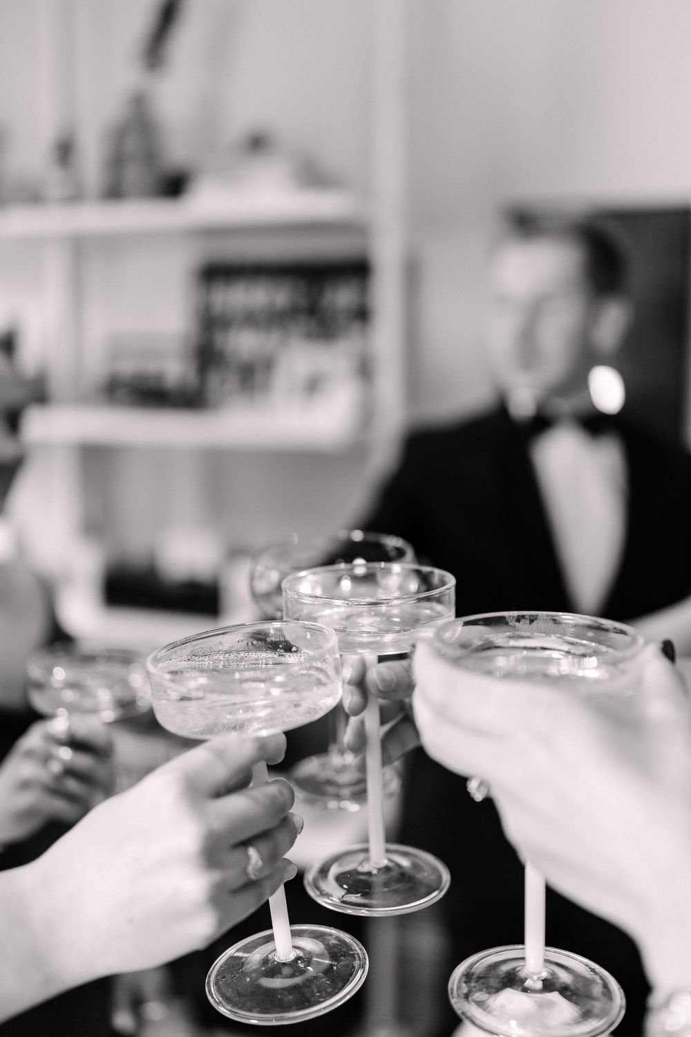Black and white photo of hands toasting with champagne coupe glasses at an elegant formal event before, St Mary Redcliffe Church wedding