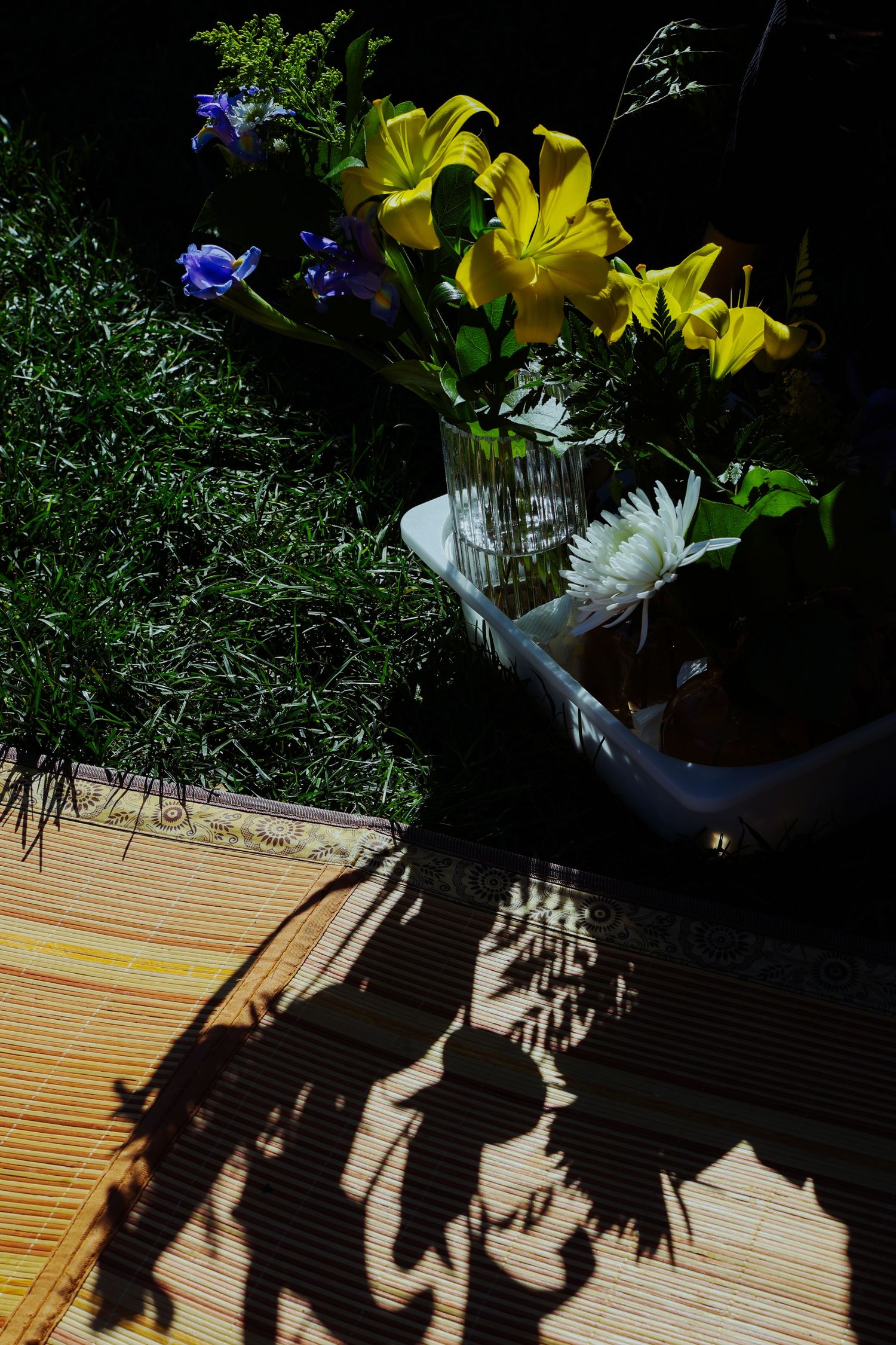 A couple picnicking in the grass, surrounded by different fruits and flowers at the Lewis MacAdams Riverfront Park in Los Angeles.