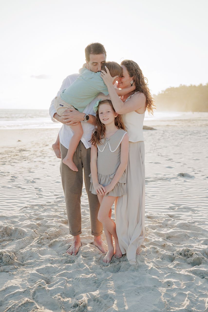 Family sharing a warm embrace on the beach during a Punta Mita family photo session.
