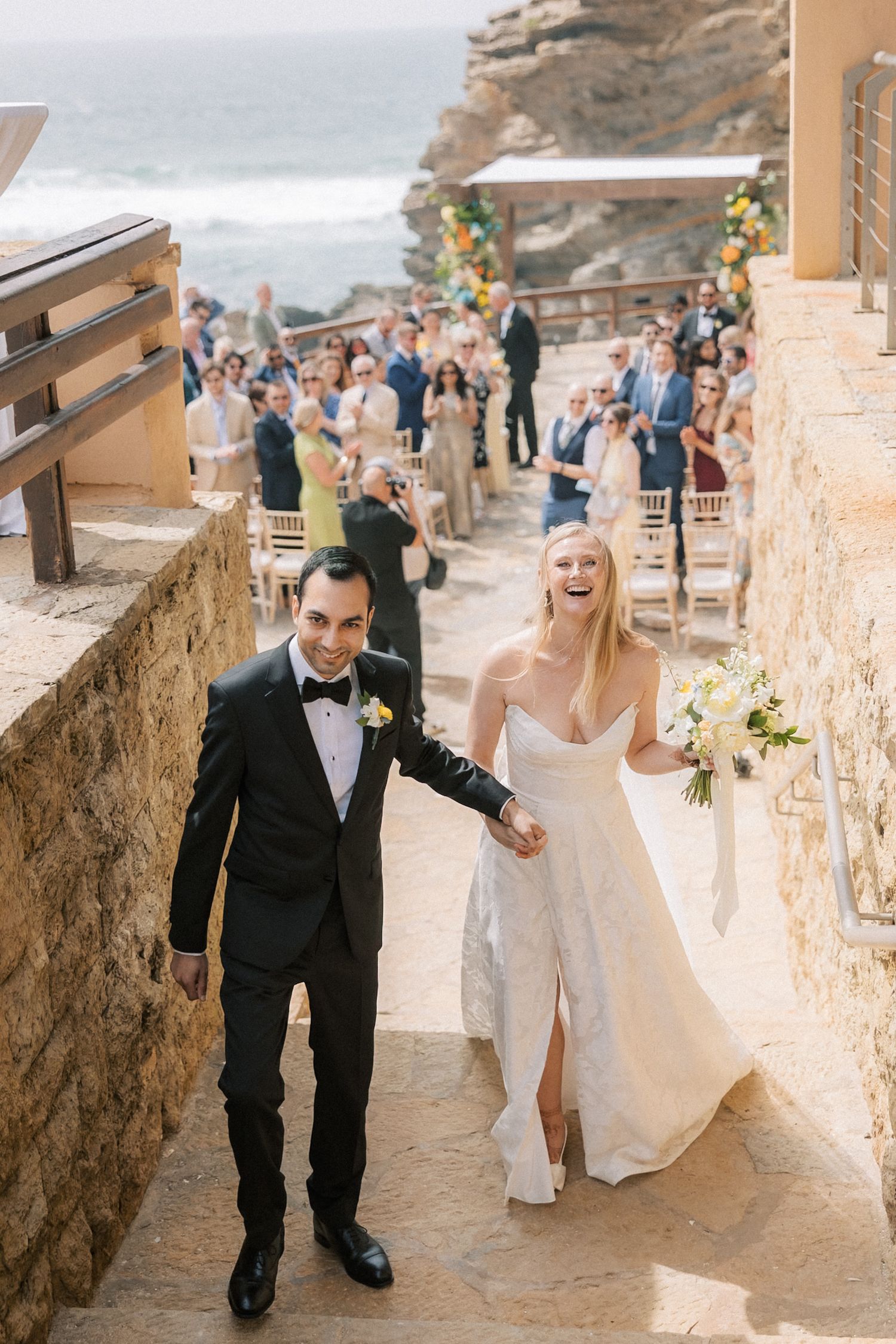 Bride and groom walking back down the aisle after their oceanfront wedding ceremony in Cascais.