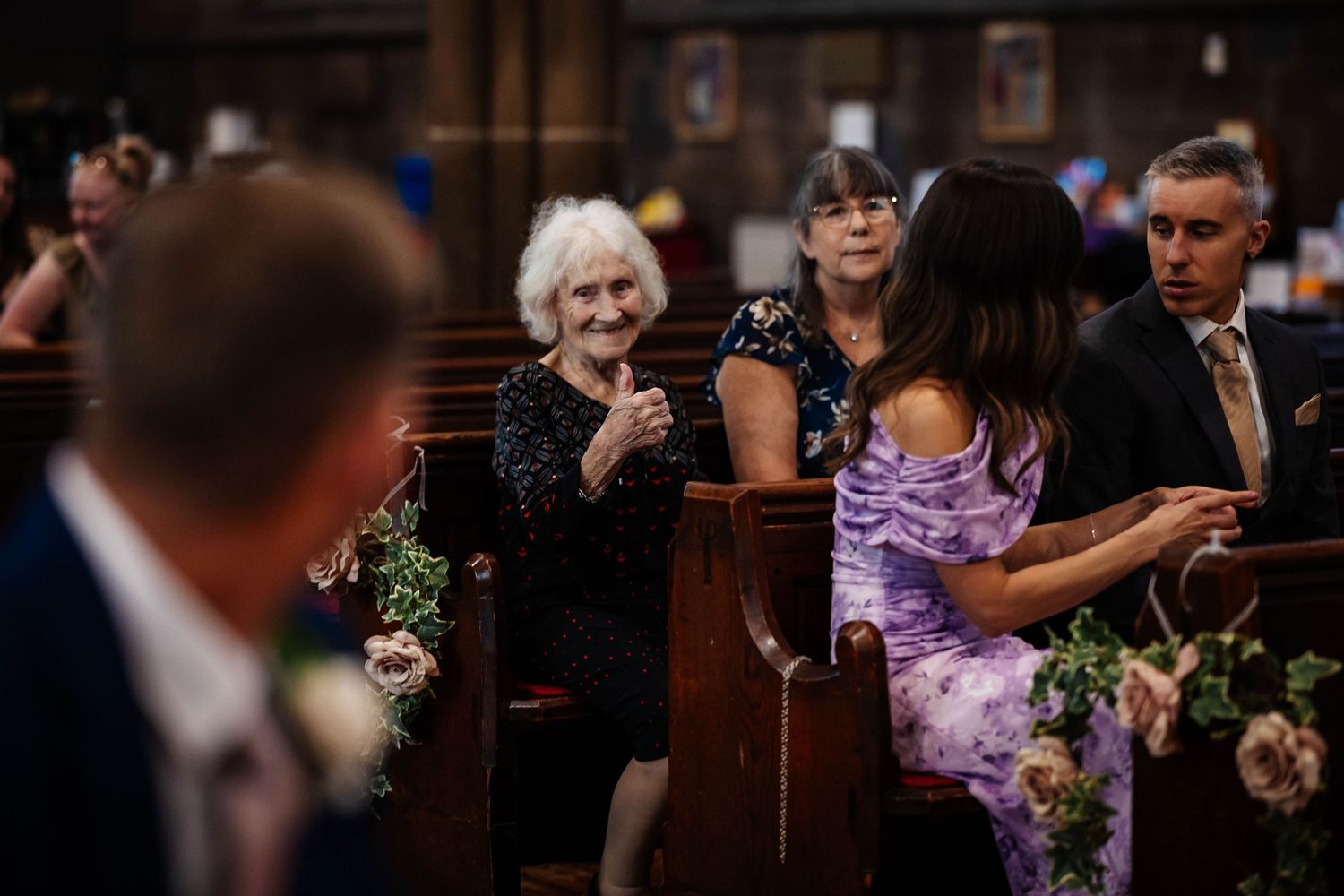 candid moment of grandma giving the groom a thumbs up in a church in Worsley captured by Lynette Matthews Photography