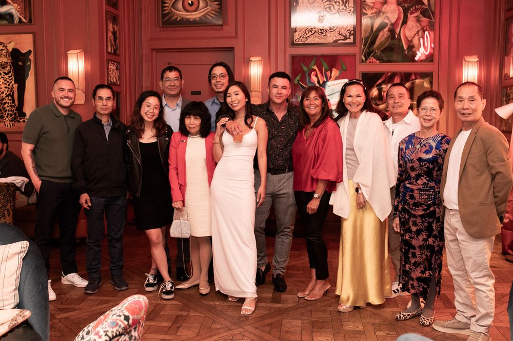 Group of people posing together smiling at an elegant indoor party.