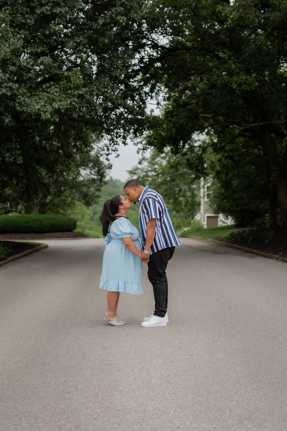 A romantic couple pose for proposal photos on a tree-lined path, moving through four sequential moments.