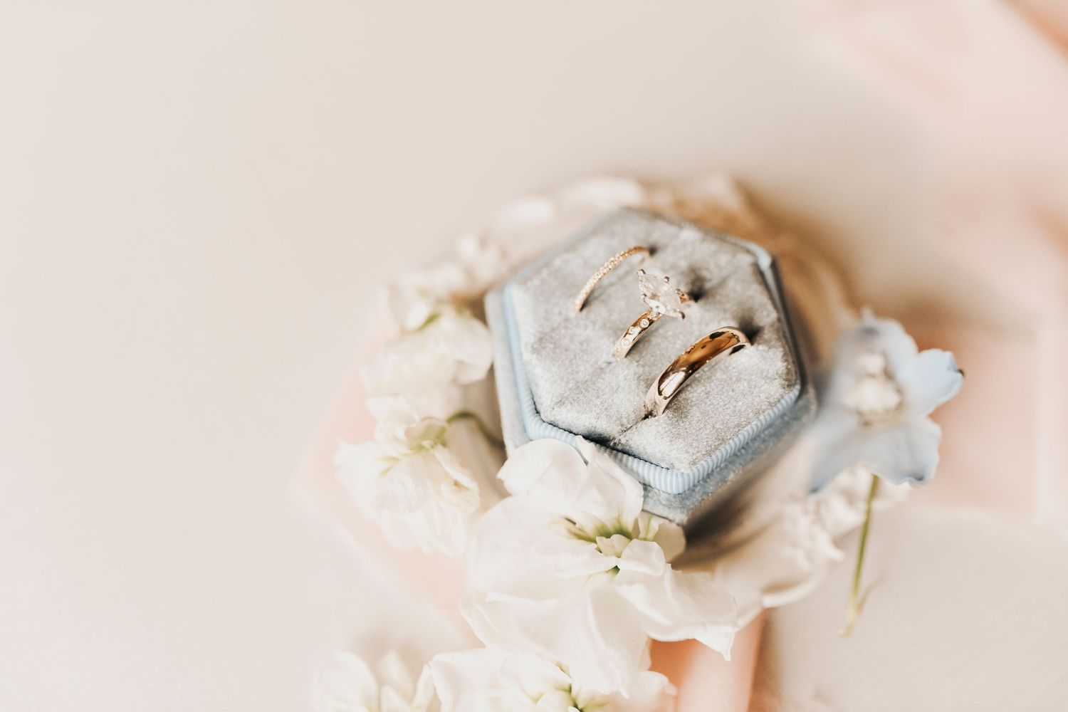 Three wedding rings styled with romantic florals at The French Farmhouse