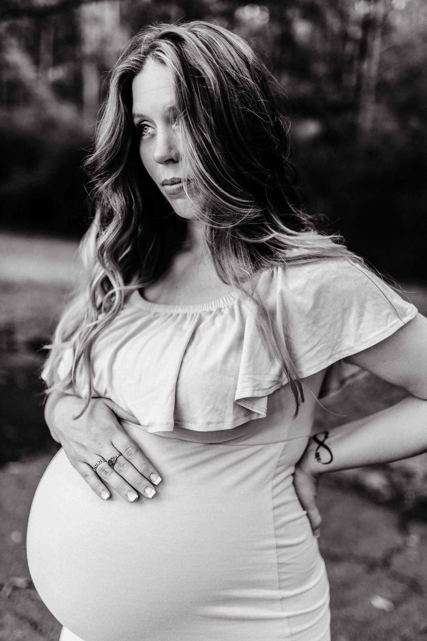 A dramatic black and white maternity portrait of an expecting mother cradling her baby bump during a North Georgia photo session