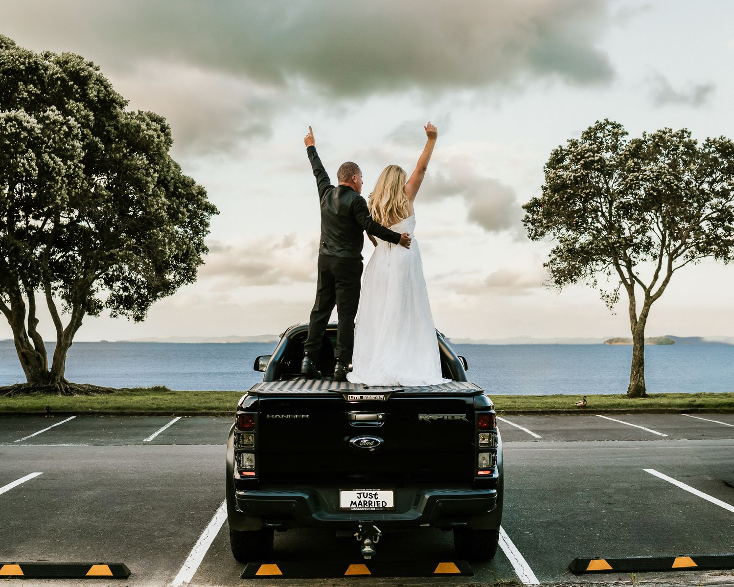 Auckland wedding photography of a newlywed couple celebrating on the back of a truck