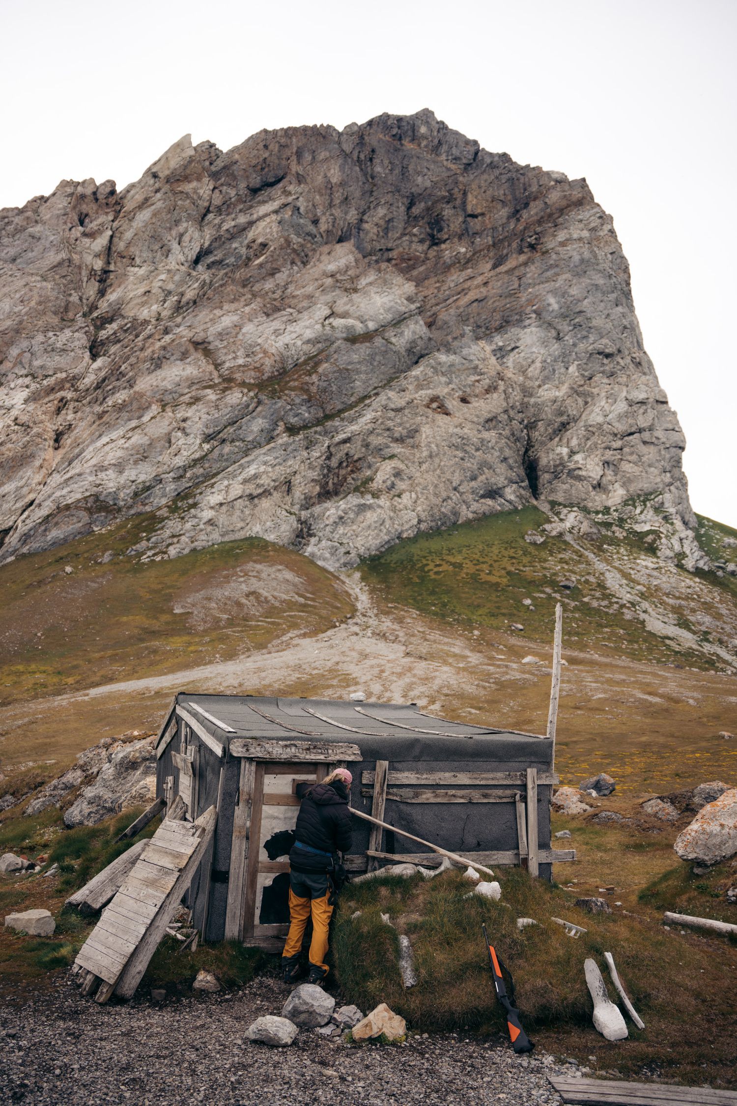 gnalloden.jpg	Cabane de refuge inspectée par un randonneur au pied de la falaise de Gnålloden