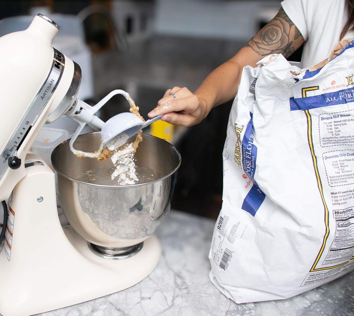 Woman dumping flour into mixer for her branding photos in strongsville.
