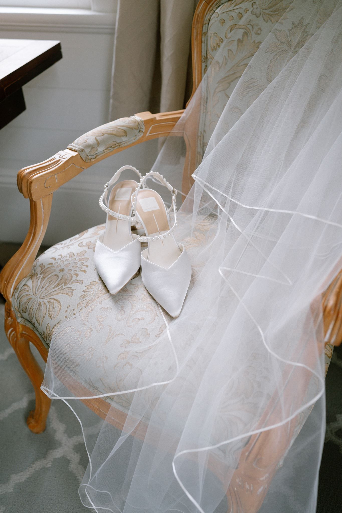 Bridal shoes and veil laid across a chair at Historic Hill House in Willis Texas.