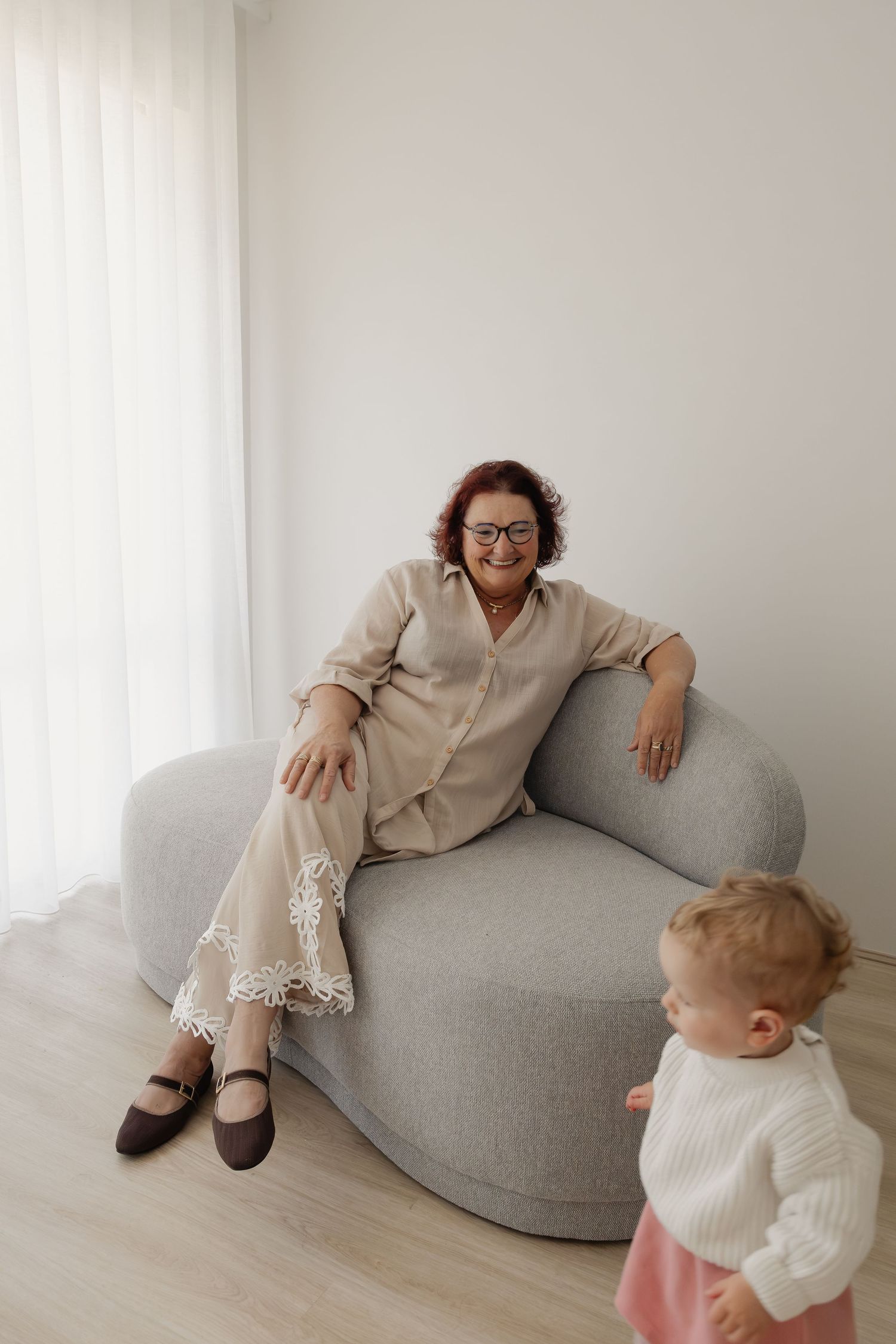 Smiling woman toward a young child playfully reach during a softly lit family portrait in Wannanup home studio.