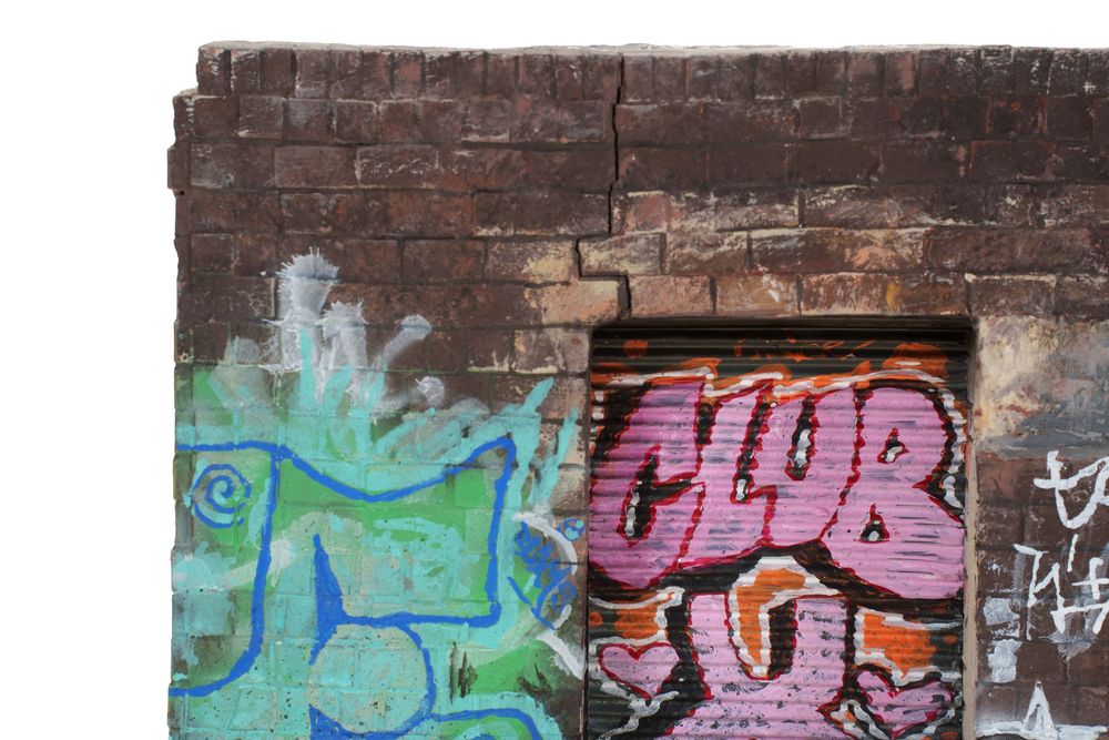 Colorful graffiti art on an old brick wall featuring the word CLUB in pink and orange spray paint.