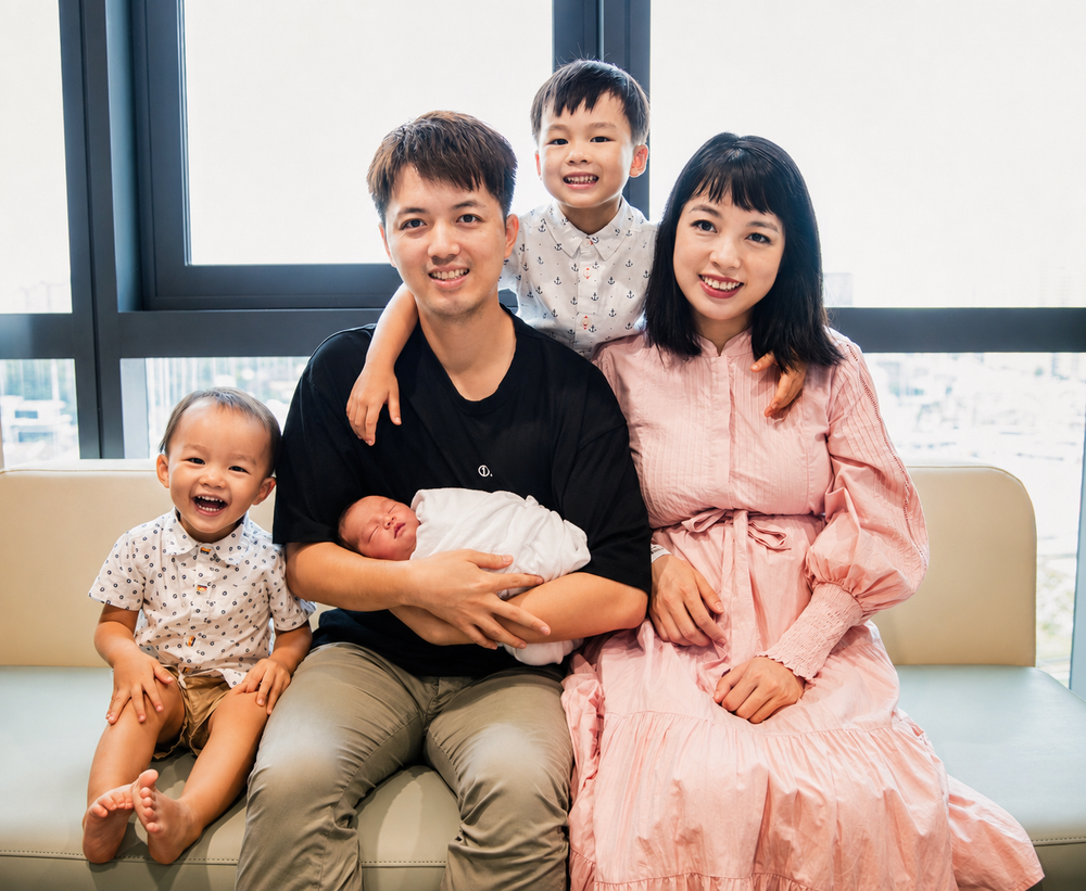 Happy Asian family of five with newborn baby posing for portrait.