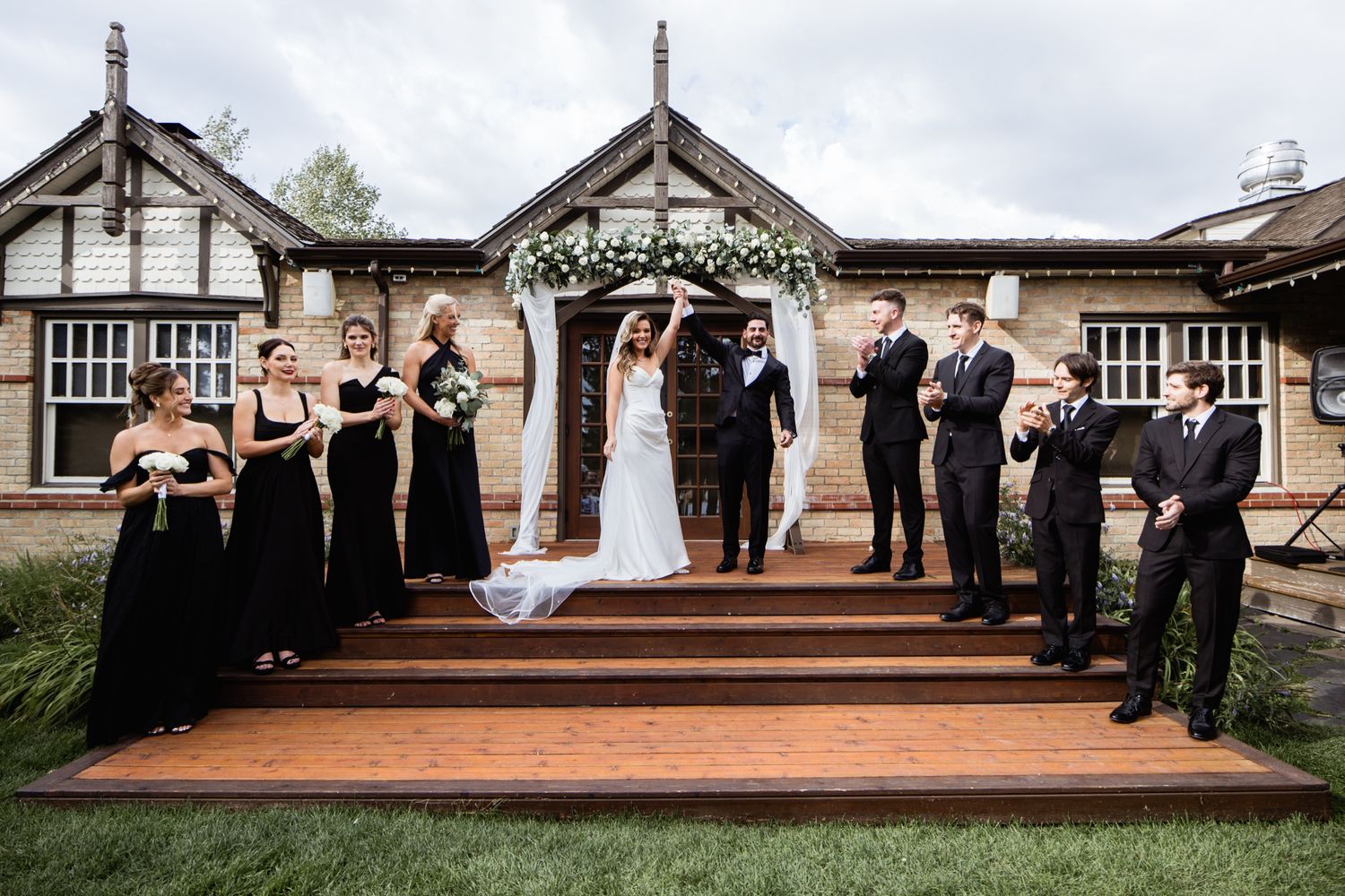 Calgary wedding photographer – wedding party with the bride and groom celebrating on the steps of a heritage venue