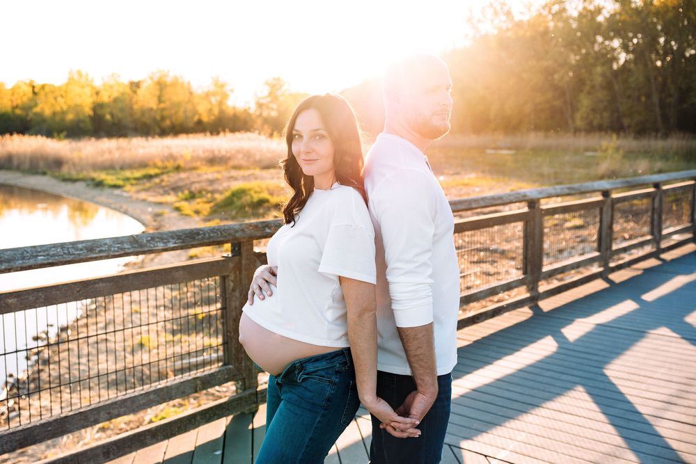 Couple standing back to back holding hands Summer Outdoor Maternity Session Algonquin, IL
