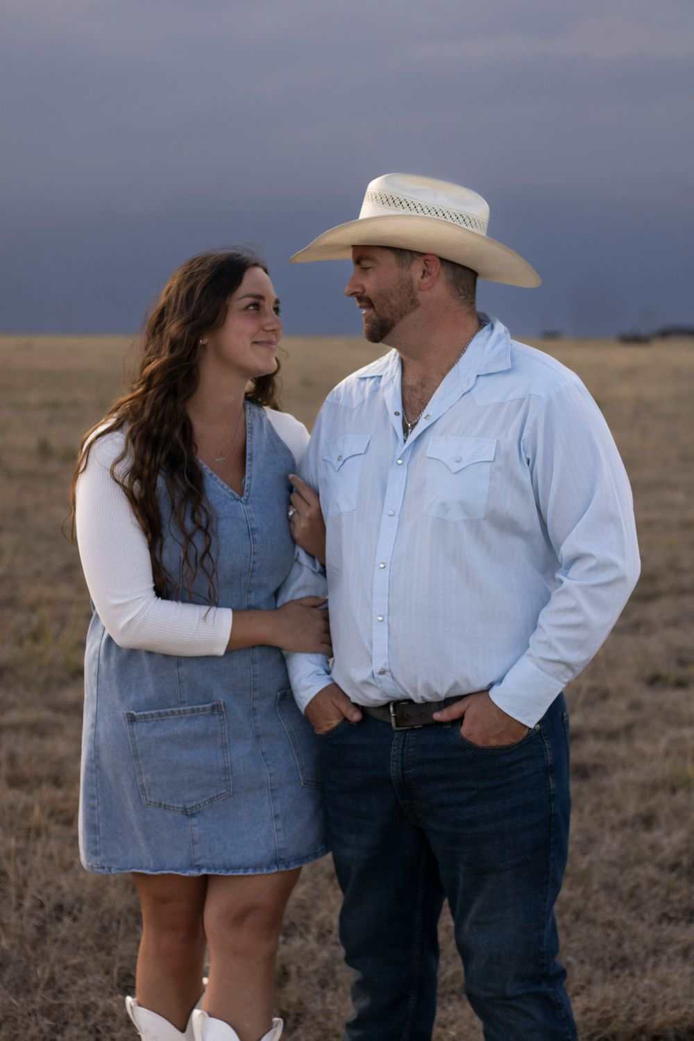A young couple during a family photo session at an open field in Amarillo, Texas