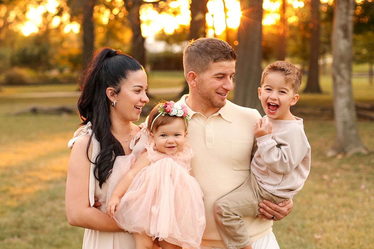 Family with 2 children all in neutral clothes, smiling at the camera, Keli Tetzlaff Photography