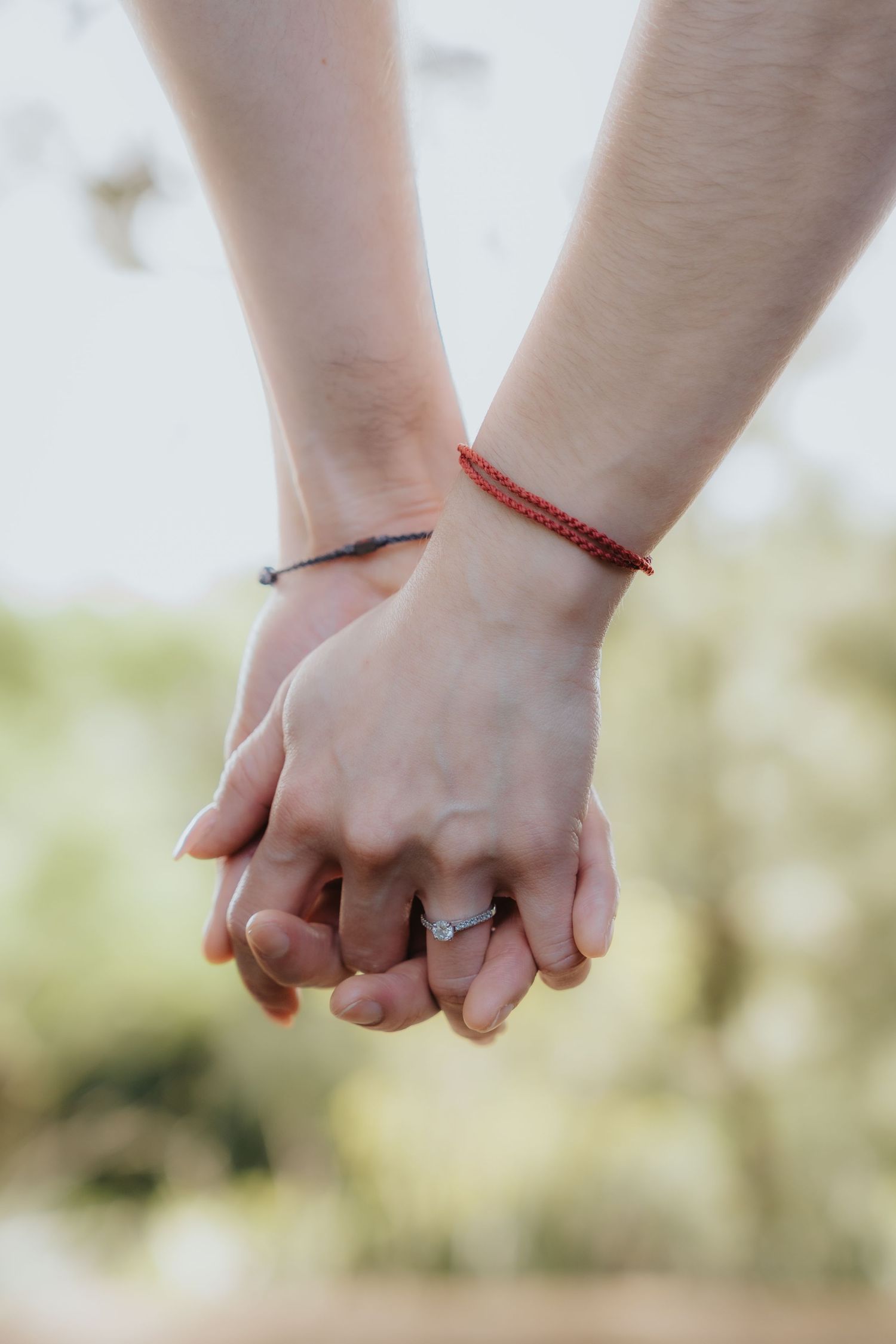 Detalle de manos tomadas en sesión de compromiso al aire libre / Detail of couple holding hands in outdoor engagement session.