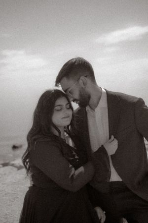 Romantic black and white portrait of couple sharing intimate moment outdoors.
