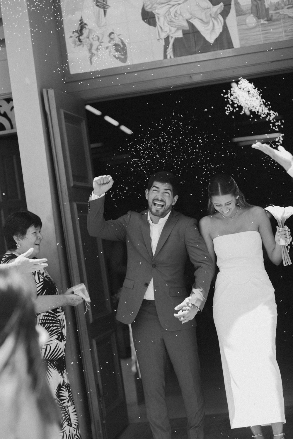 A black and white photo shows people dancing and laughing at what appears to be a wedding reception or party.