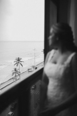 Dreamy black and white photo of beach view through window with silhouette.