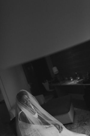 Artistic black and white photo of wedding veil in dim lighting.