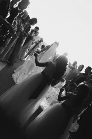 Black and white photos show a crowd of people dancing at what appears to be a social gathering or celebration.