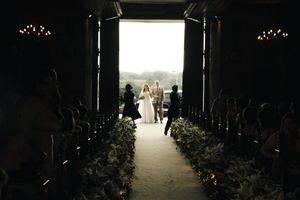 A silhouetted figure walks down a dark corridor with dramatic backlighting creating an ethereal glow.
