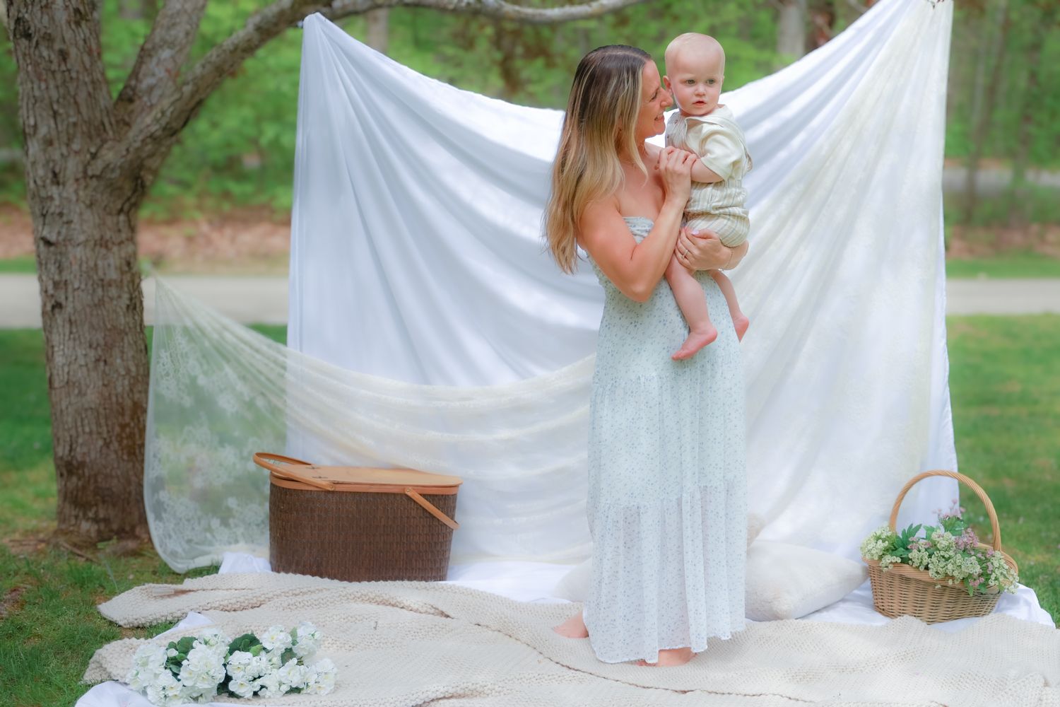 Outdoor family photoshoot with white backdrop hanging between trees.