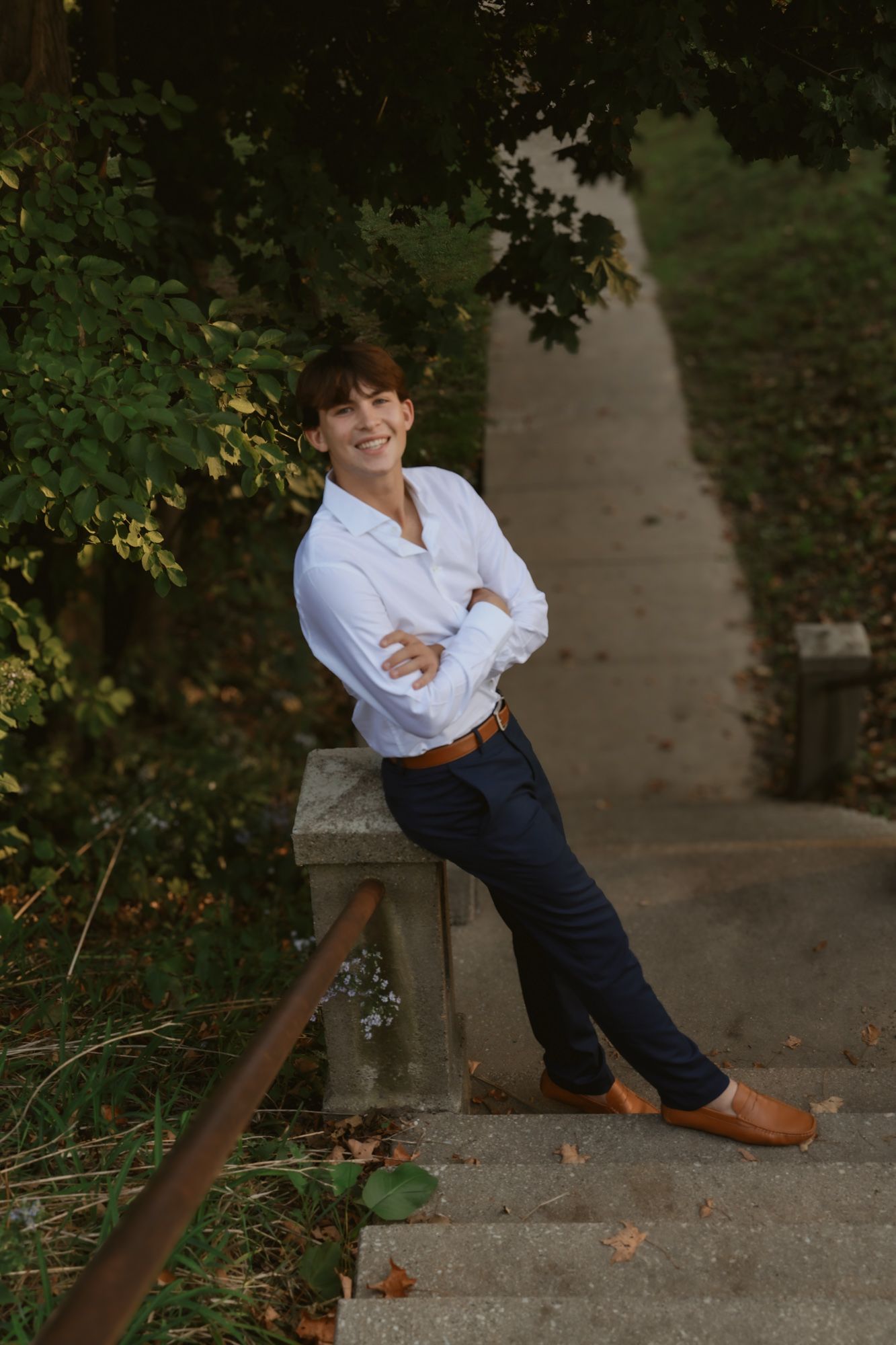 A series of playful poses on concrete steps surrounded by autumn foliage and dappled sunlight.
