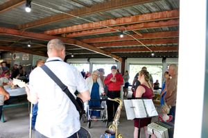 Group of people socializing in a covered outdoor venue space.
