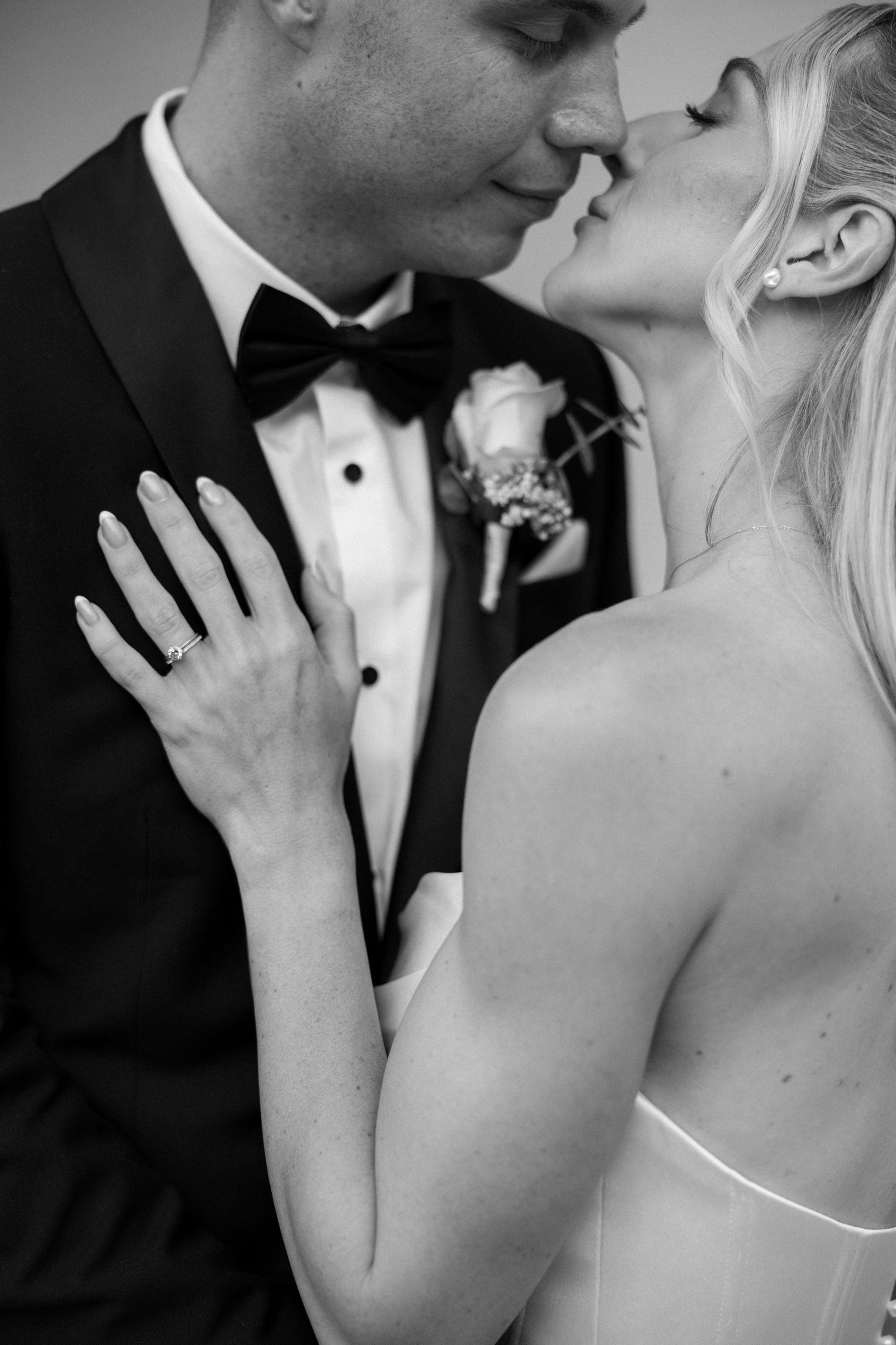 Close-up of a romantic moment between newlyweds in formal attire.