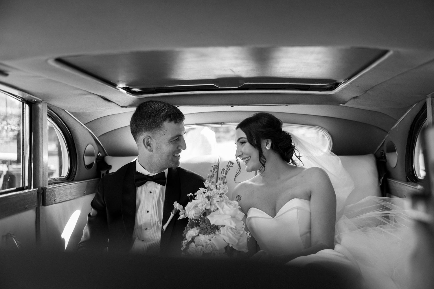A series of black and white wedding photos showing intimate moments inside a classic car.