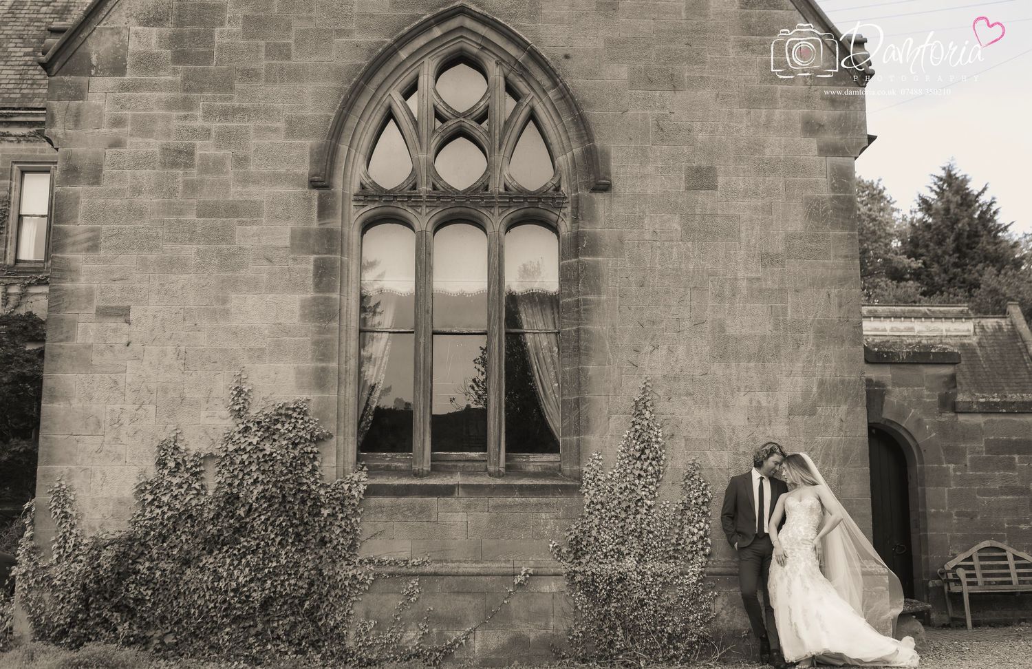 A wedding ceremony takes place inside a church with stained glass windows in the background.